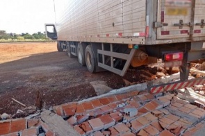 Motorista bêbado derruba 20 metros de muro tentando manobrar caminhão