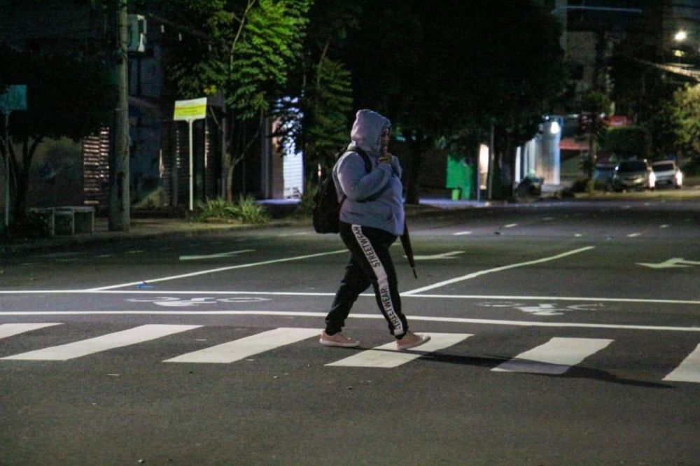 Pedestre, bem agasalhada, atravessa rua de Campo Grande (Foto: Juliano Almeida)
